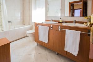 a bathroom with two sinks and a tub and a toilet at Apartamentos Turisticos Avila Villa Carmen II in Avila