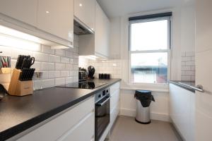 ロンドンにあるParkside London Apartment (SS3)の白いキッチン(コンロ、窓付)