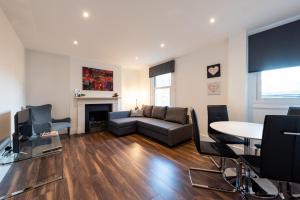 a living room with a couch and a table at Parkside London Apartment (SS3) in London