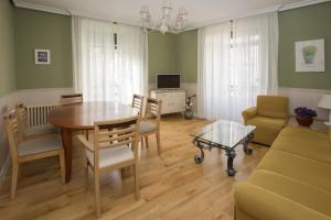 a living room with a table and chairs and a couch at Apartamentos turisticos Avila La Catedral in Avila