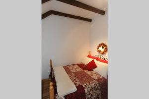 a bedroom with a bed with red pillows at Red Stonecutters Cottage, Doolin in Carrowauff