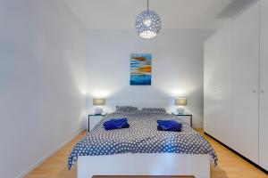 a white bedroom with a bed with blue pillows at Apartment with Stunning Seaviews in Sliema