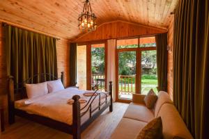 a bedroom in a log cabin with a bed and a couch at Sea Valley Lodge in Faralya