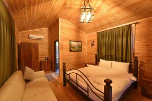 a bedroom with a bed and a couch in a room at Sea Valley Lodge in Faralya