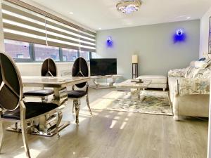 a living room with a table and chairs and a couch at Queen Stay Apartments in Sheffield