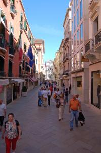 un grupo de personas caminando por una calle en Hotel Torino, en Venecia