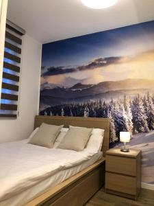 科帕奥尼克Silver Kop apartmani的一间卧室配有一张大床,床上有雪覆盖的树木