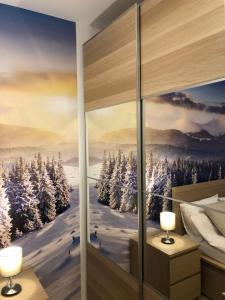 科帕奥尼克Silver Kop apartmani的卧室的墙上挂着一幅冬季场景画