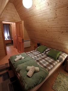 uma cama num quarto de madeira com toalhas em Domek u Marysi em Zakopane