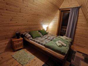 um quarto com uma cama num chalé de madeira em Domek u Marysi em Zakopane