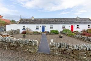 a white house with red and blue doors at Blue Sky Cottage, Doolin in Carrowauff