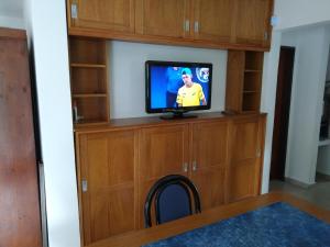 una stanza con una TV in una libreria di Casa con pileta privada a Tanti