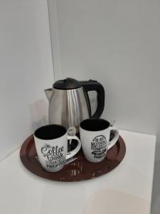 マドリードにあるPensión Corberoのコーヒーマグカップ3本のトレイ
