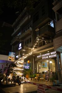 Una motocicleta estacionada frente a un edificio por la noche en The BoB Hostel, en Bangkok