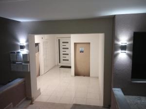 a hallway of a bathroom with a door and lights at Crystal Blue Apartments in Nea Kalikratia