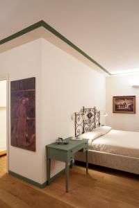 a room with a bed and a table with a bed and a painting at Borromeo Rooms Bed & Living in Vimercate