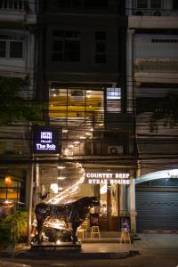 a building with a statue in front of it at night at The BoB Hostel in Bangkok