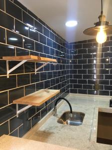 a kitchen with blue tiled walls and a sink at Pousada Vila Appia in Cabo Frio