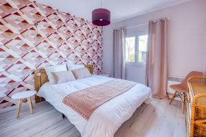 a bedroom with a large bed with a geometric wall at Le Grand Cottage Nature Bien-Etre du Tarn entre Toulouse et Albi & Les Cottages du Tarn in Peyrole