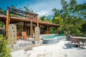 a house with a swimming pool and a pavilion at Yoga Maya Villa in Gianyar