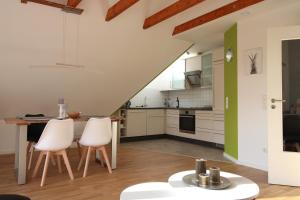an open kitchen with white cabinets and a green wall at CASA STROBL in Landsberg am Lech