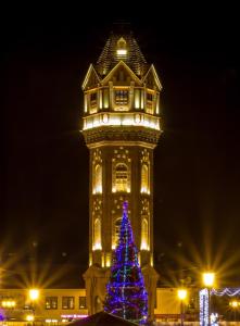 un árbol de Navidad frente a un edificio con una torre en Cottage in Staraya Russa, en Stáraya Rusa