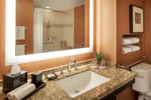 a bathroom with a sink and a toilet and a mirror at Hyatt Regency Phoenix in Phoenix
