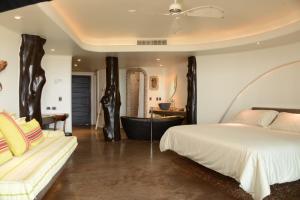 a bedroom with a bed and a bathtub and a bed and a couch at Nayara Hangaroa in Hanga Roa