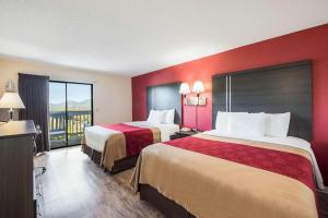 a hotel room with two beds and a balcony at Econo Lodge - Waynesville in Waynesville