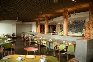 a restaurant with tables and chairs and a bar at Nayara Hangaroa in Hanga Roa