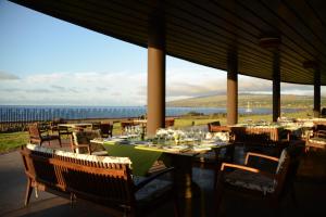 a restaurant with tables and chairs with a view of the ocean at Nayara Hangaroa in Hanga Roa