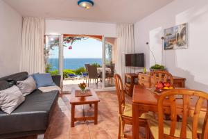 a living room with a couch and a table at Residencial Playa Mar in Cala Mendia