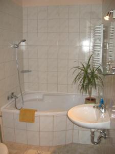 a bathroom with a bath tub and a sink at Napkorong Fogadó és Vendégház in Piliscsaba