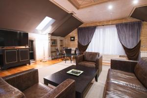 a living room with leather furniture and a flat screen tv at Eclat Luxury Hotel in Belgrade