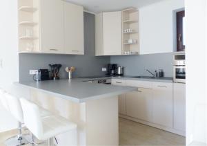 a white kitchen with white cabinets and white appliances at Guest House Magyarlukafa in Magyarlukafa