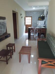 a living room with a couch and tables and a kitchen at Chalés Caribe brasileiro - Chale 2 in Maragogi +16 photos