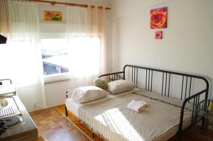um quarto com uma cama com duas almofadas e uma janela em Apartment Matea em Matulji