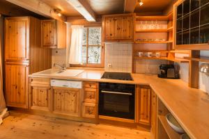 a kitchen with wooden cabinets and a stove top oven at Das Kitz - deLuxe Chalet Valerie in Reith bei Kitzbühel