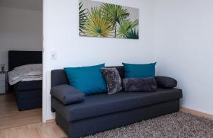 a couch with blue pillows in a living room at Haus am Marktplatz in Aigen im Mühlkreis