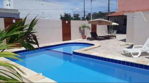 カルアルにあるHotel Itaparicaのパティオとパラソル付きのスイミングプールを提供しています。