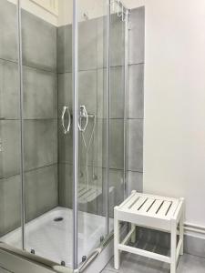 a shower stall with a bench in a bathroom at Mirandesa Guesthouse in Porto