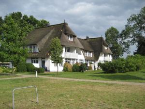 a large white house with a thatched roof at Landhaus am Haff A9 in Stolpe auf Usedom