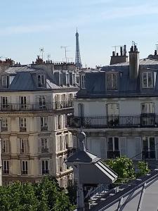 una vista de la torre Eiffel desde los tejados de los edificios en Hôtel Roi René en París