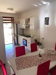 cocina con mesa de comedor y sillas rojas en ELAIA HOUSE, en Capoterra 28 fotos más