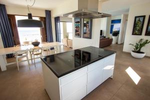 a kitchen and living room with a table and a stove at Terramar Penthouse Heros in Kralendijk