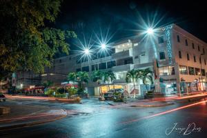 una calle de la ciudad por la noche con luces de la calle en Hotel Juan Maria, en Tuluá
