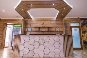 a bar in a restaurant with wooden walls and a ceiling at MANIJA Hostel in Samarkand