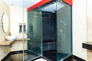 La salle de bains est pourvue d'une douche avec une porte en verre. dans l'établissement DLUXE Auto Hotel ADULTS ONLY, à Veracruz