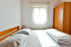a bedroom with a bed with a wooden headboard and a window at Adriatico Bungalow in Poreč