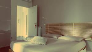 a white bed with two pillows on top of it at Efeso 19 in Rome